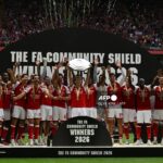 Arsenal's Norwegian midfielder #08 Martin Odegaard lifts the trophy as Arsenal's players celebrate their victory after the English FA Community Shield football match between Arsenal and Manchester City at The Principality Stadium, in Cardiff, south Wales on August 16, 2026. Arsenal won the game 3-0. (Photo by Glyn KIRK / AFP)